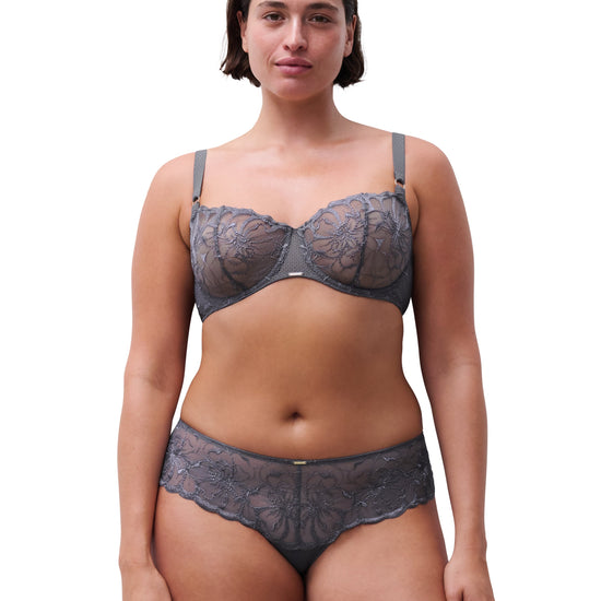 Woman wearing a navy blue top and bottoms set on a white background